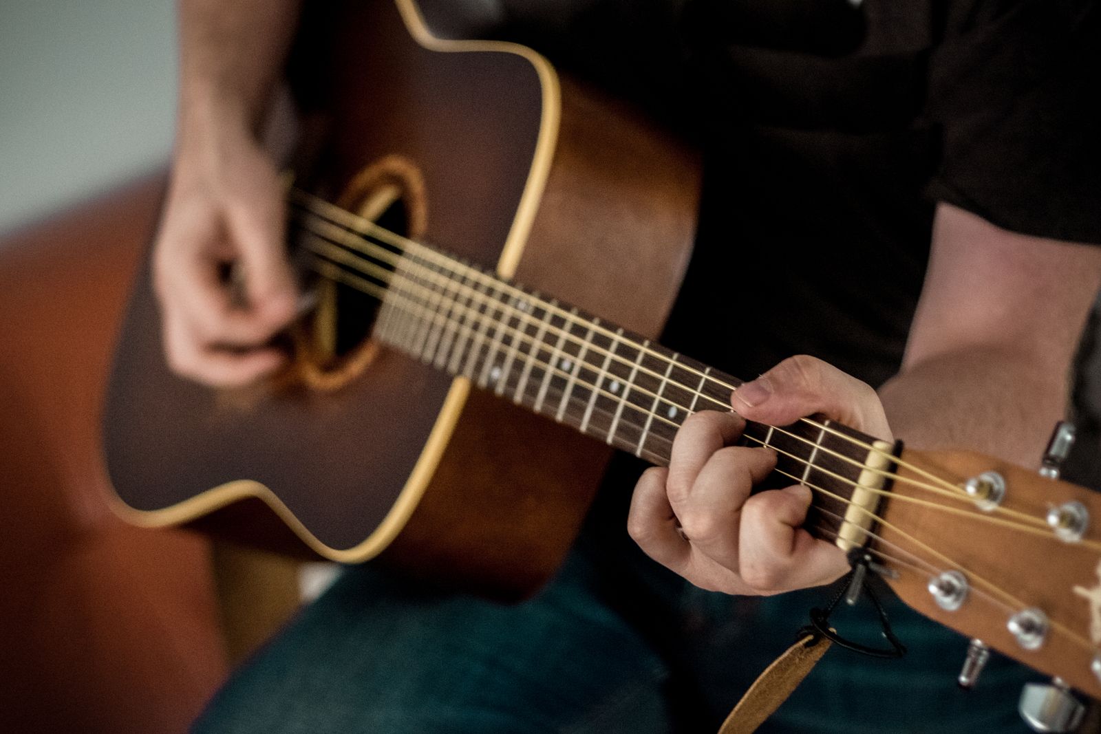 Close-up of a guitarist’s hands forming a chord on an acoustic guitar