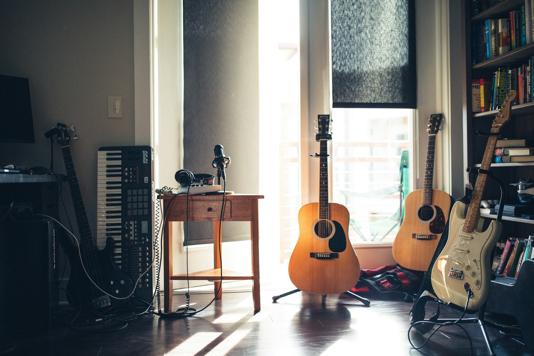 A sunlit home music room with acoustic and electric guitars on stands